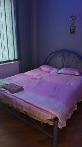 提比里斯的住宿－Lia，一张床上的床上,上面有紫色毯子