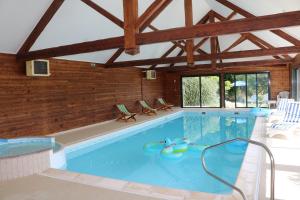 - une grande piscine avec des chaises dans une maison dans l'établissement Le Grand Connétable, à Châteauneuf-de-Randon