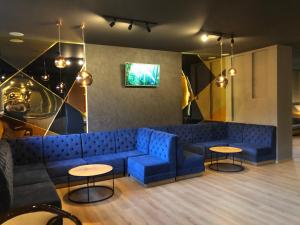 a living room with a blue couch and two tables at Park Hotel Ribaritsa in Ribarica