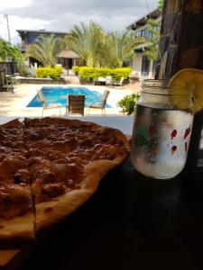 une pizza et un pot de verre avec une pizza. dans l'établissement Villas Rocher - Junior Suite 2C, à Grand Baie