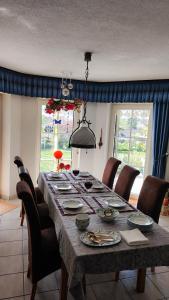 a dining room table with chairs and a large table with plates at Luxus-Wohnung mit Garten, Terrasse & Wall-Box bei Dinkelsbühl in Dinkelsbühl