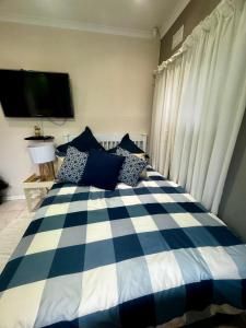 a blue and white checkered bed in a bedroom at Granny Flat &Solar in Ramsgate