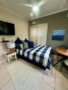 a bedroom with a blue and white bed and a table at Granny Flat &Solar in Ramsgate