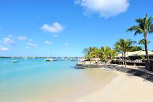 una playa con palmeras y barcos en el agua en Villas Rocher - Junior Suite 2C en Grand Baie