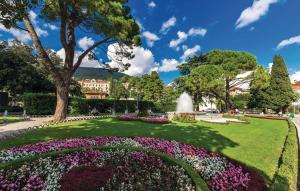 einen Garten mit einem Brunnen und Blumen in einem Park in der Unterkunft Apartman Nora in Mučići