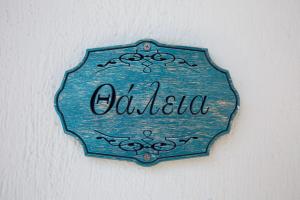 a blue sign that reads olilo hanging on a wall at Stolios in Skopelos Town