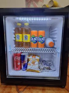un réfrigérateur ouvert rempli de boissons et de nourriture dans l'établissement Les Chambres, à Pagani