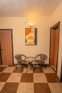 una mesa y sillas en una habitación con una planta de tablero de ajedrez en Hayat Apartments & Homes, en Lagos