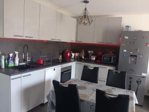 a kitchen with white cabinets and a table with chairs at MIRANEO in Miramas