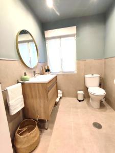 een badkamer met een wastafel, een toilet en een spiegel bij Sweet Aviles Apartamento in Avilés