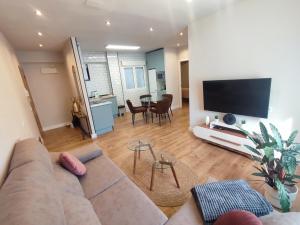 Sweet Aviles Apartamento في أفيليس: غرفة معيشة مع أريكة وتلفزيون بشاشة مسطحة