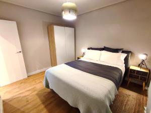 Sweet Aviles Apartamento في أفيليس: غرفة نوم بسرير كبير وملاءات بيضاء وسوداء