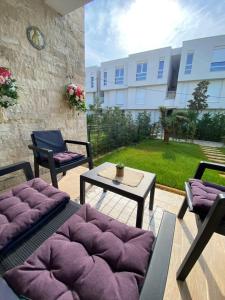 un patio con sillas, una mesa y un edificio en Vila Margo, San Pietro Resort, Lalez, en Durrës
