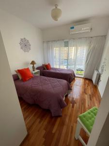 2 camas en una habitación con suelo de madera en Semipiso en Las Lomitas en Lomas de Zamora