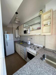 Una cocina con un refrigerador blanco y un fregadero. en Semipiso en Las Lomitas, en Lomas de Zamora