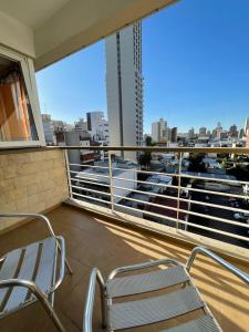 Un balcón con dos sillas y vista a una ciudad. en Semipiso en Las Lomitas, en Lomas de Zamora