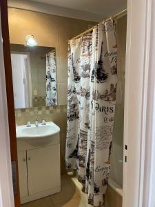 Un baño con lavabo y cortina de ducha. en Semipiso en Las Lomitas, en Lomas de Zamora