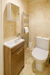 bagno con servizi igienici, lavandino e specchio di Tanyard House a Woodbridge