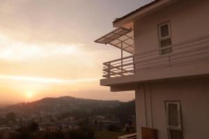 a view of the sunset from the balcony of a house at Seven Endue Delight with Mountain view on the Hill Top in Ooty