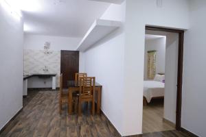 a room with a table and chairs and a bedroom at Seven Endue Delight with Mountain view on the Hill Top in Ooty