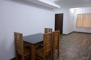 a dining room with a table and chairs in a room at Seven Endue Delight with Mountain view on the Hill Top in Ooty