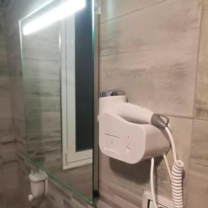 un asciugacapelli bianco in un bagno accanto a uno specchio di SETTIMO SOLE Affitta Camere a Taranto
