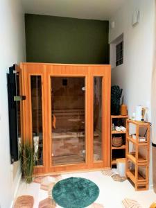 einen Holzschrank mit Glastüren im Wohnzimmer in der Unterkunft Chez Sam in Libourne