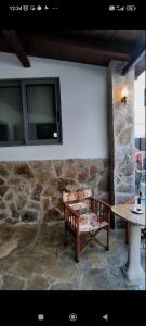 a room with a bench and a table and a stone wall at Petrino in Kalamata