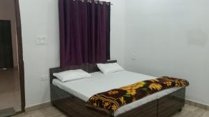 Bett in einem Zimmer mit einem lila Vorhang in der Unterkunft Shree Banke bihari home stay in Mathura