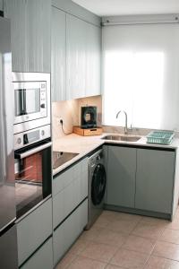 a kitchen with a microwave and a washer and dryer at Casita Molino de Erillas in Alora