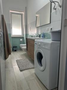 a bathroom with a washing machine and a sink at Rent House Scauri in Minturno