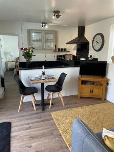 un soggiorno con tavolo e sedie e una cucina di Guest Suite in Porthleven With Private Garden a Helston