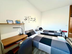 una camera d'albergo con 2 letti, una scrivania e un letto di [AlpinHome] Family & Friends a Trento