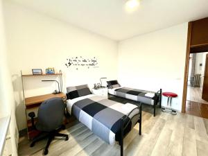 una camera con 2 letti, una scrivania e una sedia di [AlpinHome] Family & Friends a Trento