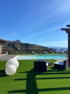 a view of a pool with green grass and lights at Villa Da Campo in Giardini Naxos