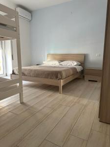 a bedroom with a bed and a wooden floor at Rent House Scauri in Minturno