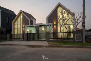 a house with a fence in front of it at Kanchanaburi Modern Home in Kanchanaburi City