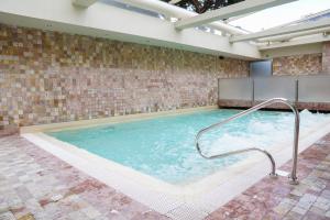 a large swimming pool with a handrail in a building at Hotel Grifone Firenze - Urban Pool & Spa in Florence