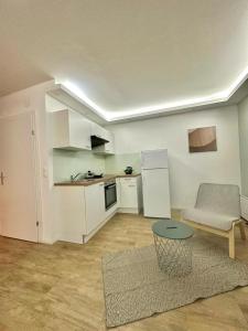 ein Wohnzimmer mit einer Küche, einem Sofa und einem Tisch in der Unterkunft AR Living Vienna Klosterneuburger Studios in Wien