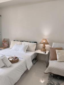 a bedroom with two beds and a table and a lamp at Wind Residences Tower 2 Tagaytay in Tagaytay