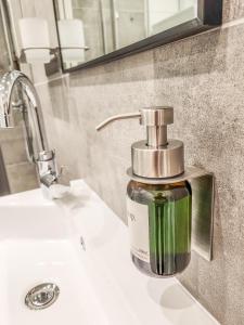 a soap dispenser sitting on top of a bathroom sink at GELI Homes A2208 - 2x Zimmer, 2x Kingsize Bett, 1 bis 4 Personen, Parkplatz, TV, Wifi, top Küche, Kaffee, Tee in Lünen +26 photos
