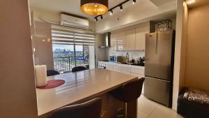 a kitchen with a large table and a refrigerator at 2 BR Condo Free Wifi & Netflix - Circulo Verde, Eastwood Libis, Quezon City in Manila