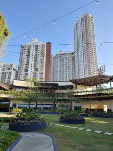 two tall buildings in a city with a park at 2 BR Condo Free Wifi & Netflix - Circulo Verde, Eastwood Libis, Quezon City in Manila