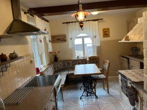 a kitchen with a table and a couch in it at Drewniany Domek w Zakątku Andrzeje Śniczany 18 in Sniczany +71 photos