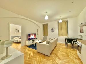 ein Wohnzimmer mit einem Sofa, einem Tisch und einem TV in der Unterkunft AR Living Vienna Apartments & Suites in Wien