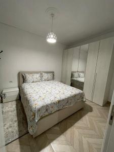a bedroom with a bed and a chandelier at RIAN GUEST HOUSE in Sarandë