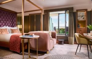 una camera da letto con un letto, una sedia e un tavolo di The Fitzwilliam Hotel a Dublino