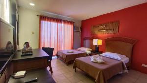 a hotel room with two beds and red walls at Eagle Point Beach and Dive Resort in Mabini