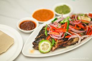 a plate of food with vegetables on a table at EL ELOLO Hotel in Dzake