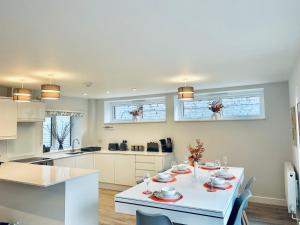 a kitchen with a white table with dishes on it at Luxury Town Centre House, Faversham in Faversham